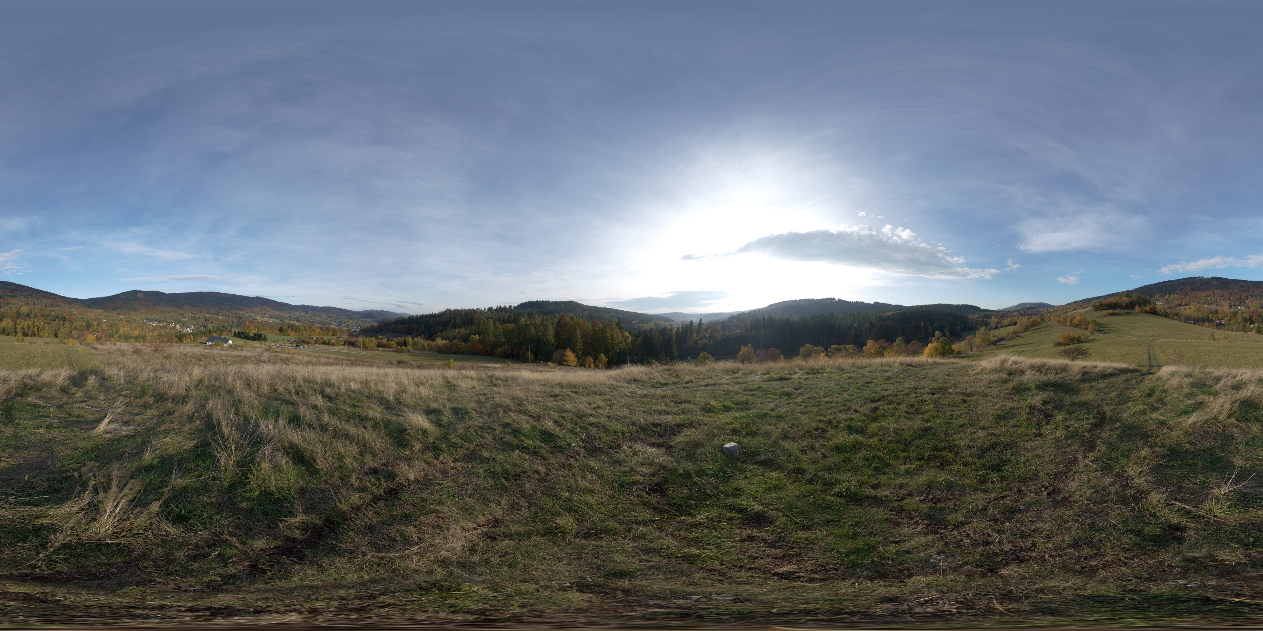 A flat two-to-one equirectangular panorama of an autumn hillside